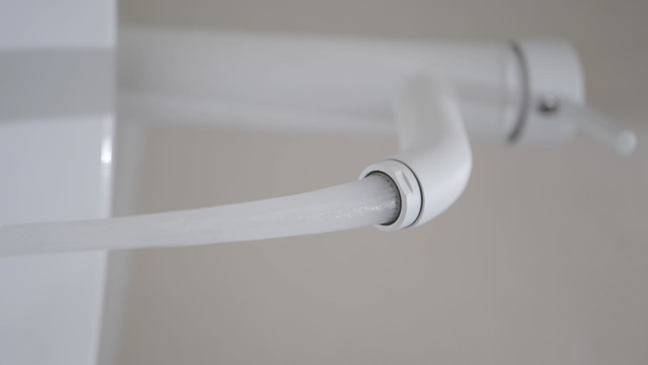 Clean Water Flowing from a Modern White Faucet