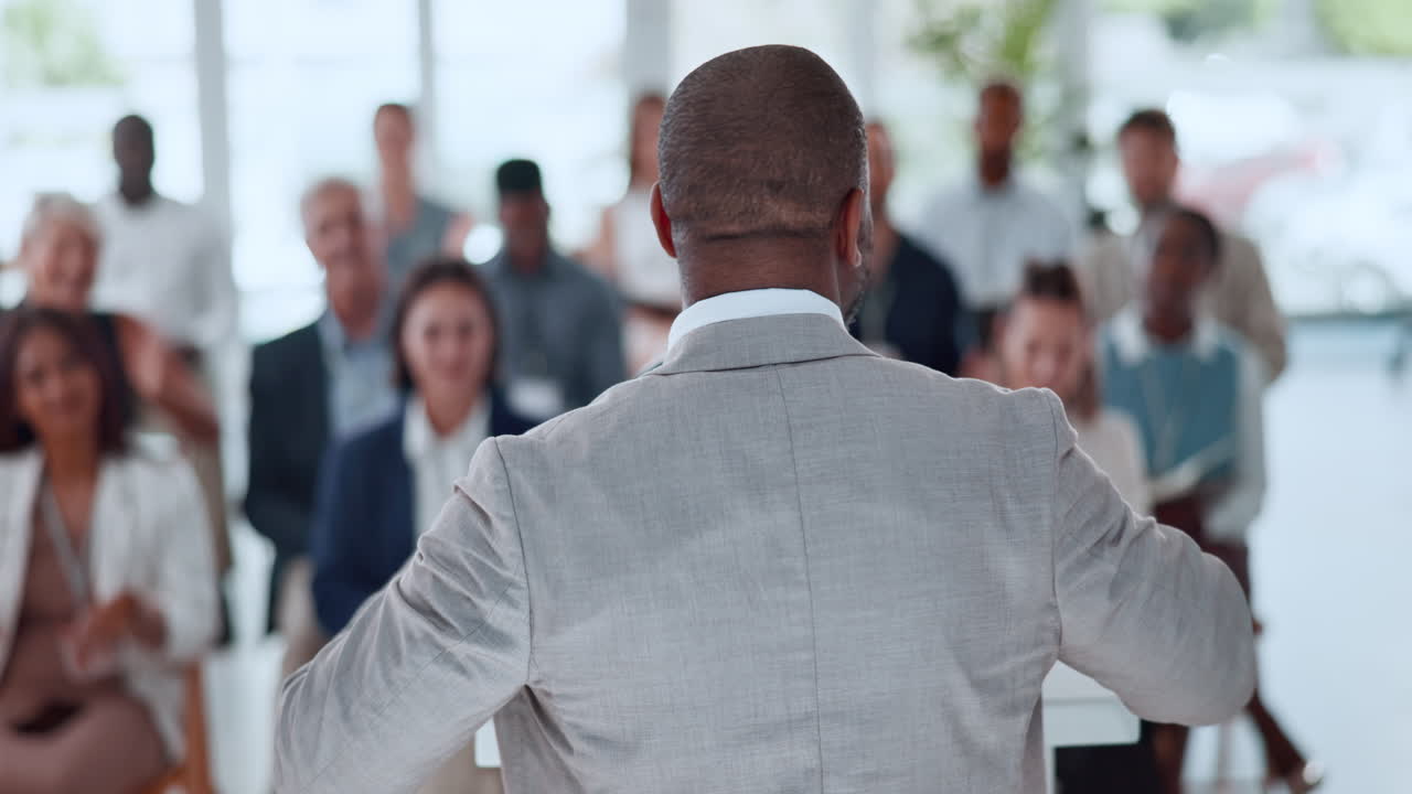 Professional Speaker Receiving Applause from Diverse Audience