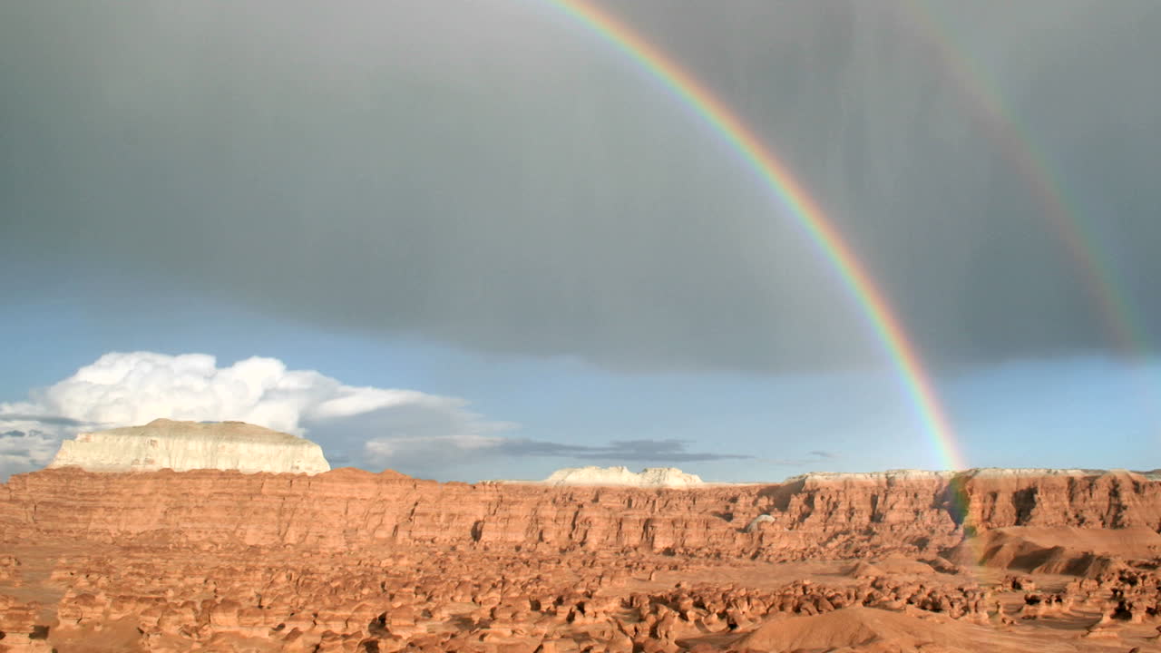 무지개가 고블린 계곡 주립 공원 위로 아치를 그리며 햇빛에 빛납니다.