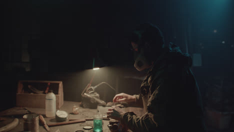 a bombmaker assembles a bomb in his workshop at night