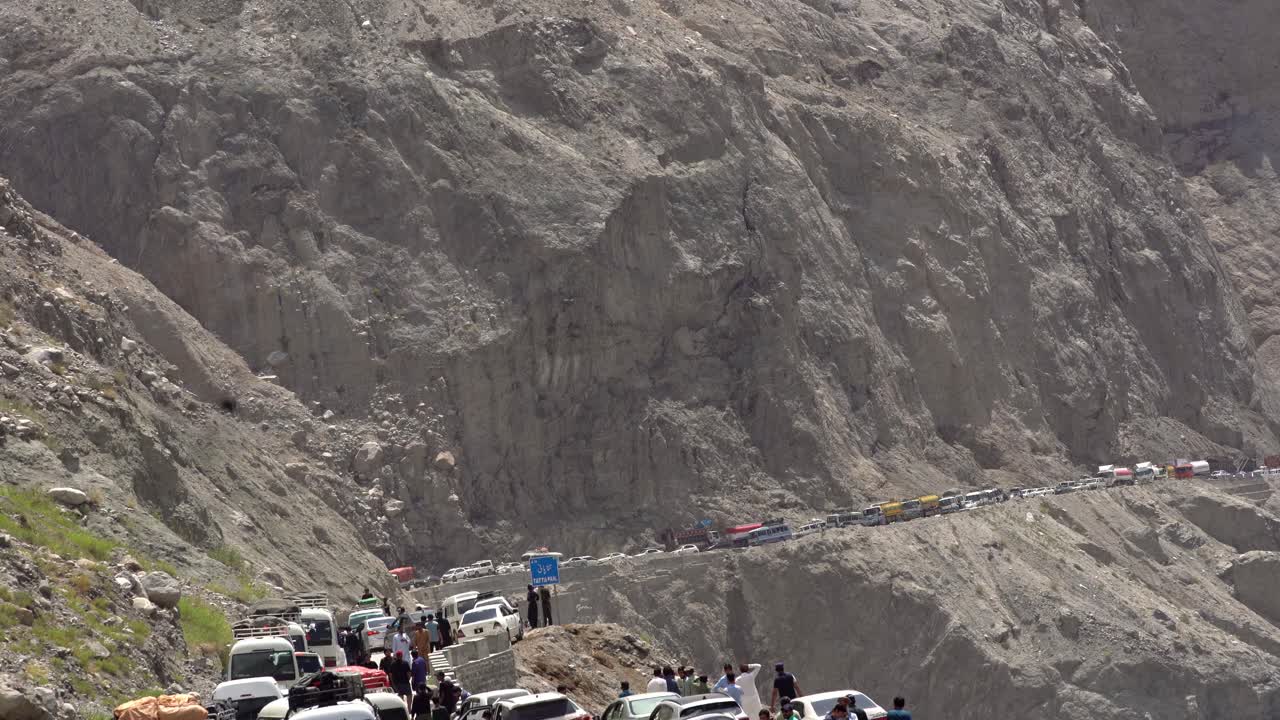 Static view of a traffic blockade in the mountains, land sliding in region of Chilas, Pakistan, cars and people