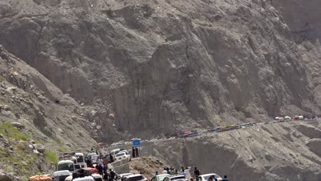 static view of a traffic blockade in the mountains, land sliding in region of chilas, pakistan, cars and people