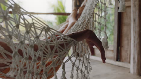 mano cercana de una mujer en una hamaca durmiendo estilo de vida cómodo de vacaciones en un complejo vacacional balanceándose pacíficamente en un perezoso día de verano en una cabaña del paraíso tropical