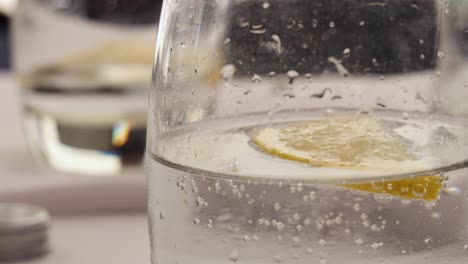 una rodaja de limón flotando en un vaso de agua