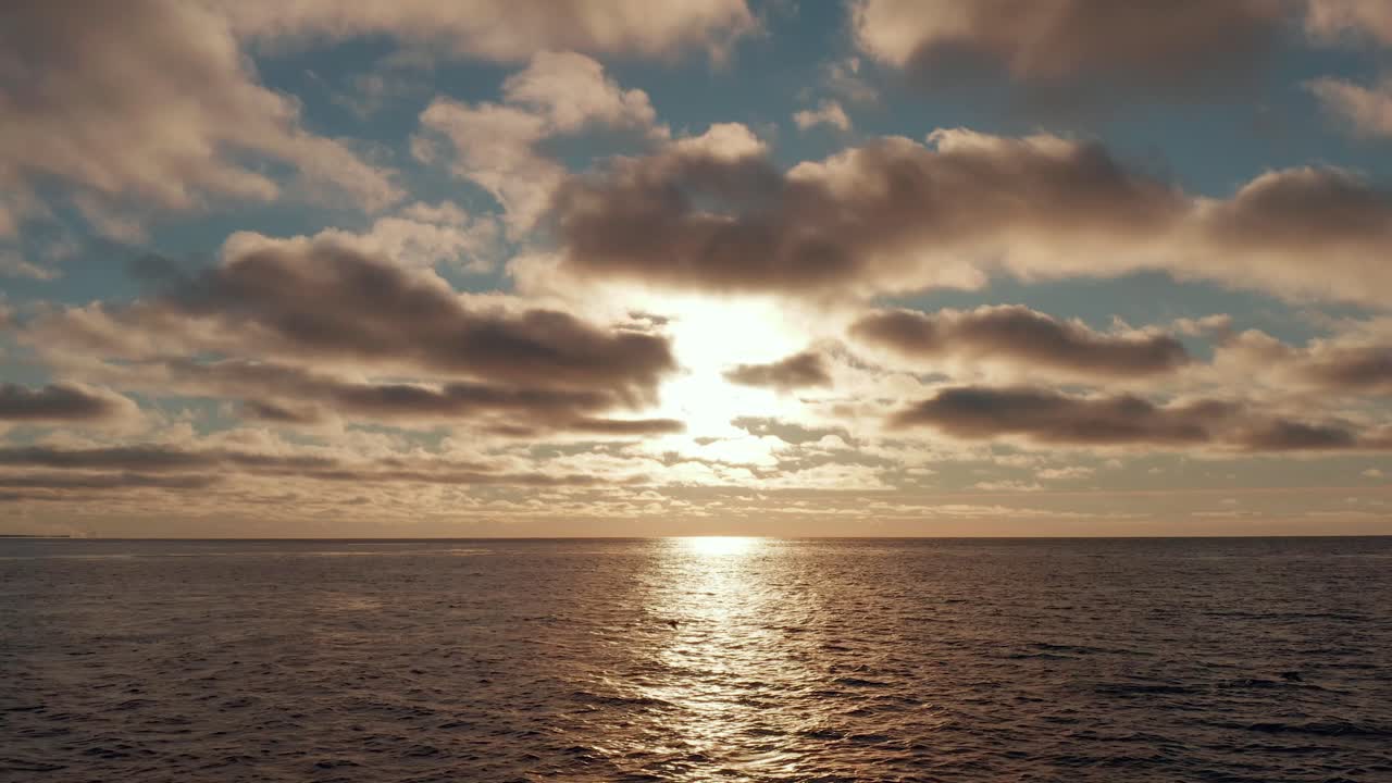 Epic aerial view of golden sunset, sunrise at sea with strong reflection