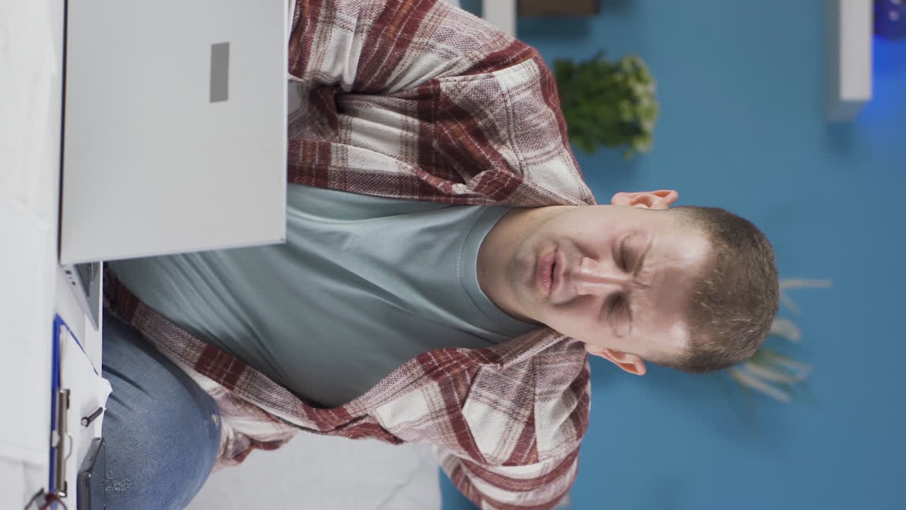 video vertical de un trabajador de oficina en casa hombre tiene dolor de espalda baja.