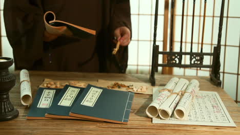 chinese medicinal materials while consulting ancient medical books, actual footage for an advertisement with the theme of traditional medicine, physician