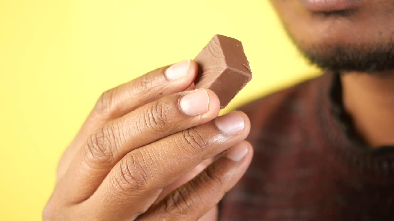 Person holding and eating a piece of chocolate