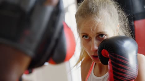 entrenador entrenando a una boxeadora en un estudio de fitness 4k
