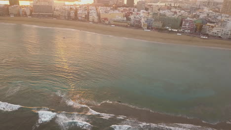 Fantastic-aerial-shot-of-development-at-dawn-on-the-beach-of-Las-Canteras-and-where-you-can-see-the-hotels,-port,-boats-in-the-area