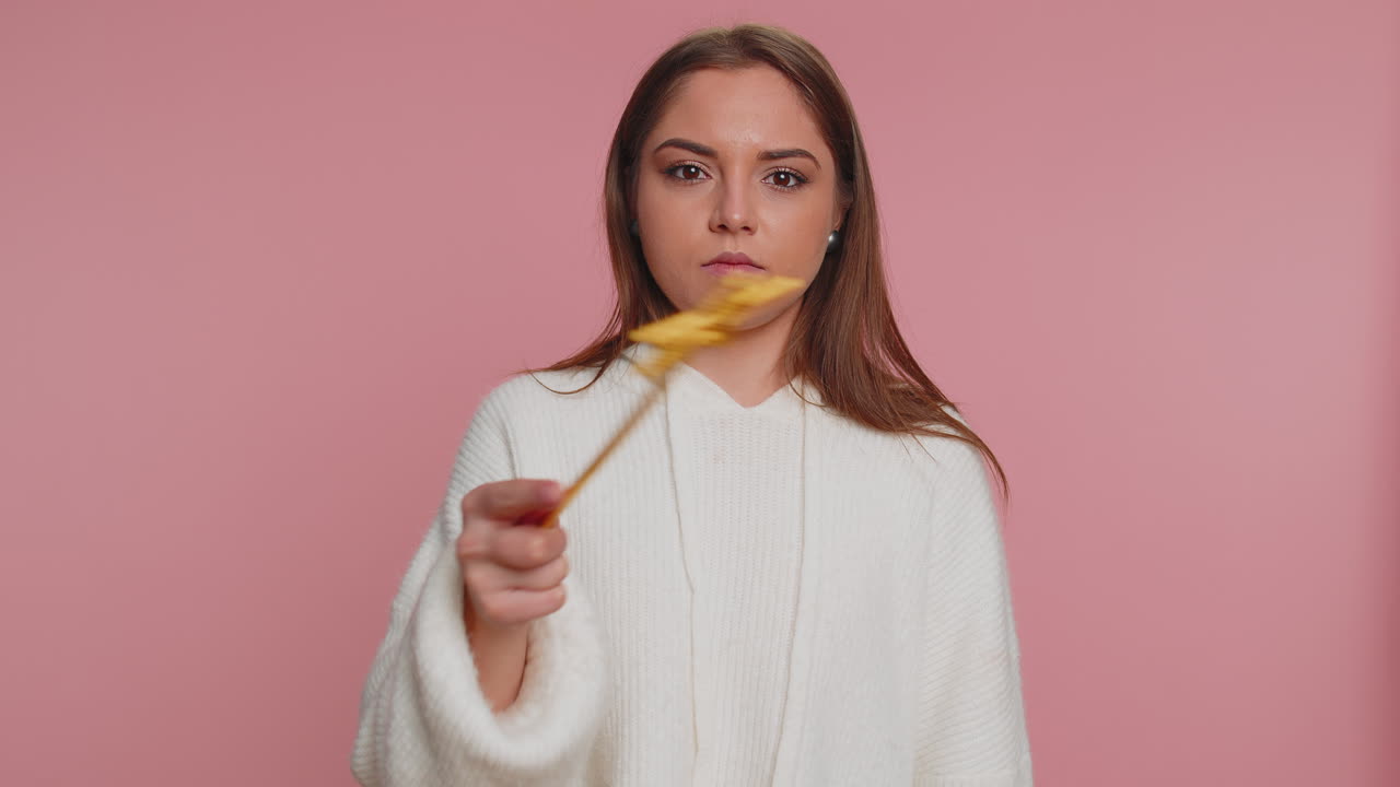 bruja mágica mujer joven gesticulando con varita mágica haciendo deseos realidad, lanzando hechizo mágico