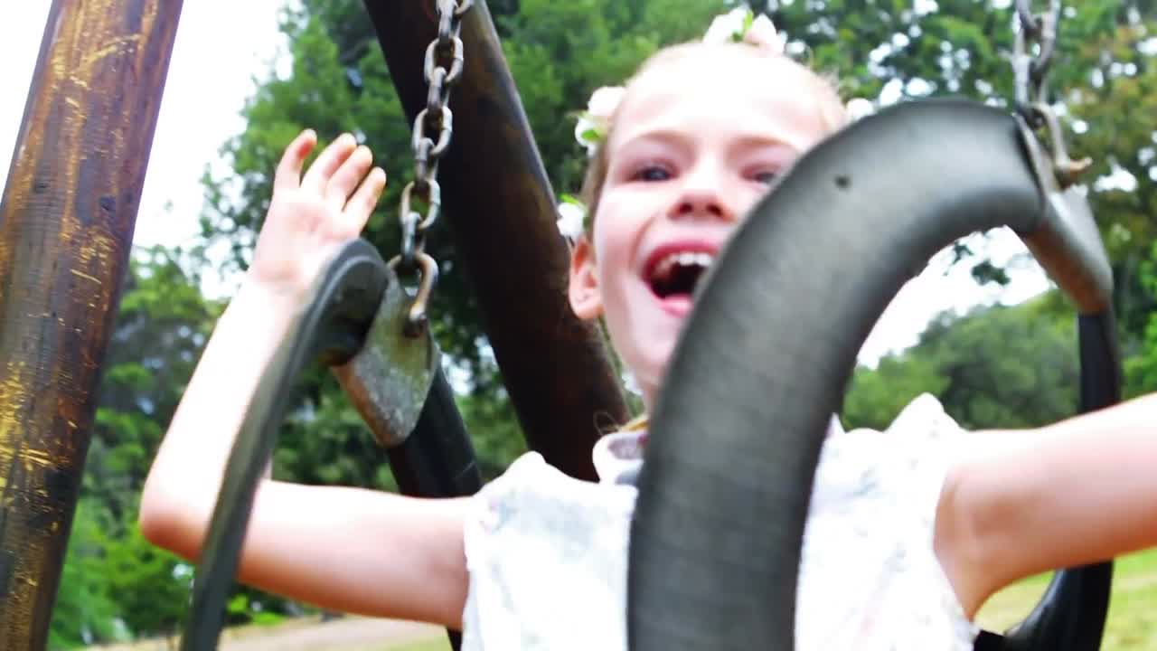 chica jugando en el columpio en el patio de recreo