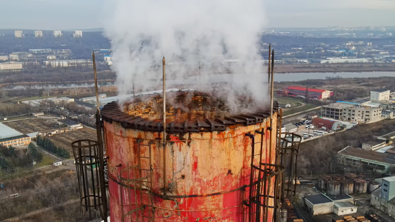 Luftfoto af Chisinau taget med drone. Rør fra varmestationen med røg, der kommer ud. Industriområde tæt på og bybillede i baggrunden. Skyet vejr. Moldova