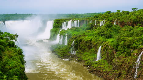 Timelapse-of-Waterfalls-of-Iguazu-around-a-big-green-area-and-a-river,-in-a-sunny-day,-Foz-do-Iguacu,-Parana,-Brazil