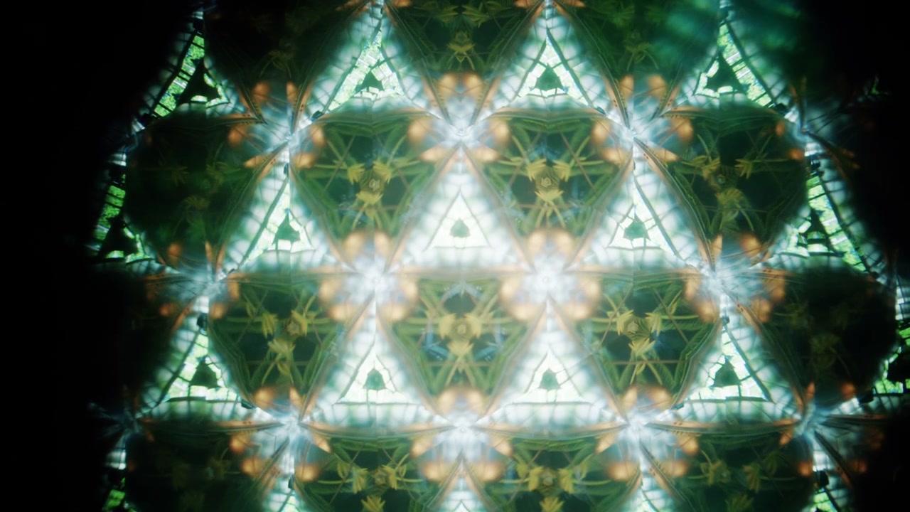 Composizione caleidoscopica colorata creata dai riflessi di oggetti di vetro e piccole luci LED, che formano motivi simmetrici a forma di stella.