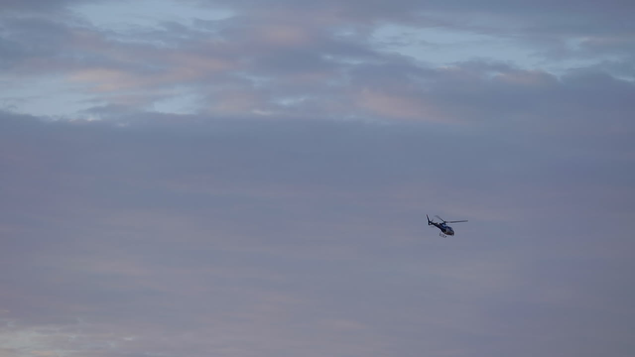 다카르 랠리를 통해 예쁜 파란색과 분홍색 하늘을 날고 있는 헬리콥터