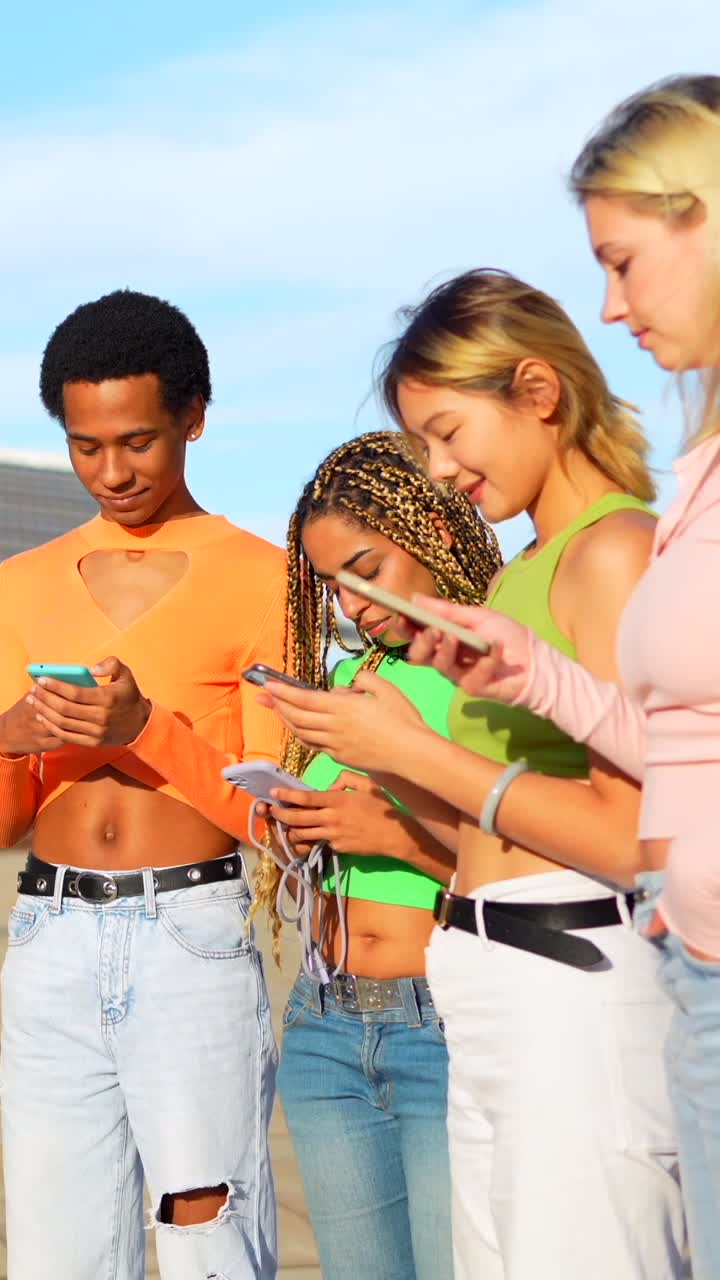 Group of Diverse Young Adults Laughing and Using Smartphones