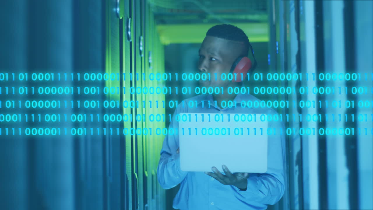 animación de códigos binarios, ingeniero afroamericano con auriculares y portátil mirando los servidores