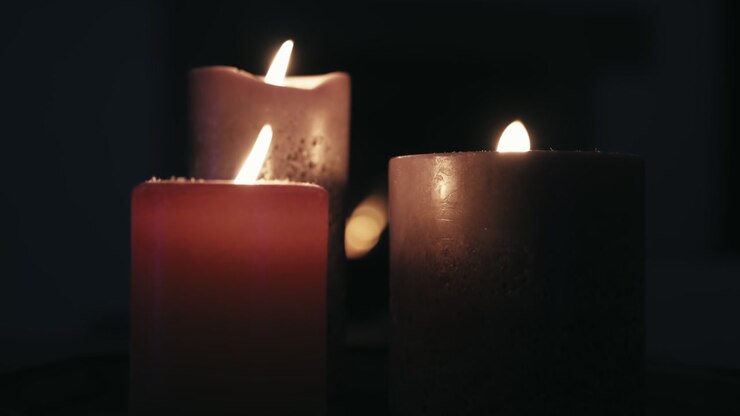 Scena romantica al rallentatore con candele accese davanti a un camino. Filmato scuro e calmo dall'atmosfera zen