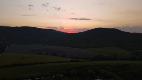 peaceful sunrise in pilis mountains. panning shot of first light behind hills. aerial view