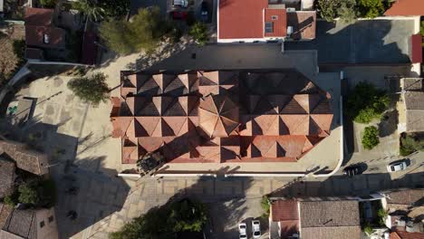 red roof of the church of st. barbara in the city center neighborhood of kaimakli, cyprus. aerial ascending shot