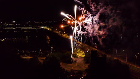 Vista-Aérea-De-Un-Fuego-Artificial-Durante-La-Noche-Junto-A-Un-Río