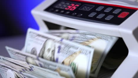 100 us dollar in money counting machine in action, close up