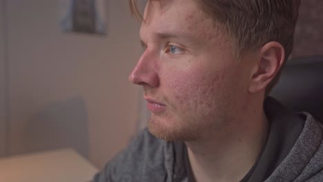 a close-up of a young man focusing on the computer monitor in front of him