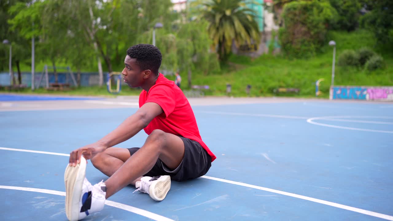 Uomo che si allunga su un campo da basket
