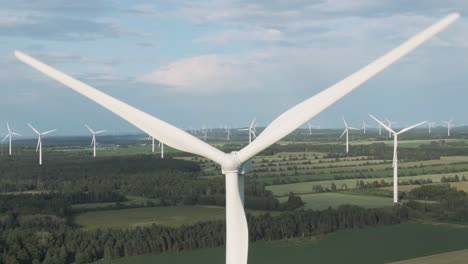 close up details of wind turbine generating renewable energy on the lush field near saint lawrence gulf in quebec, canada - ascending drone shot