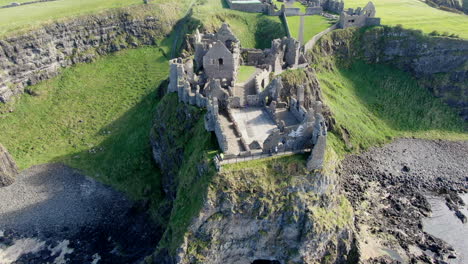 aerial shot in orbit over dunluce castle in ireland, the setting for the game of thrones series