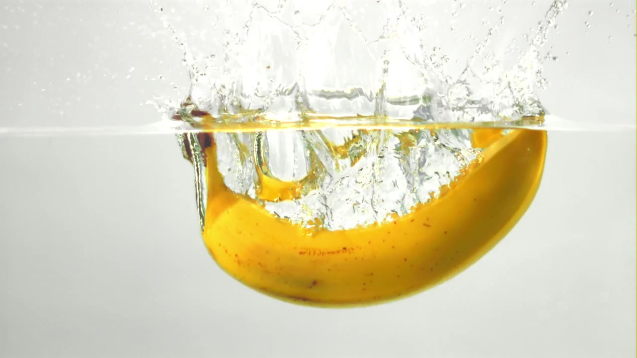 Yellow Banana Splashes into Clear Water in Slow Motion