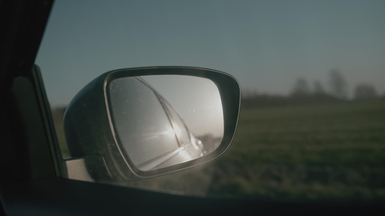 Car mirror driving through landscape. Fyn, Denmark