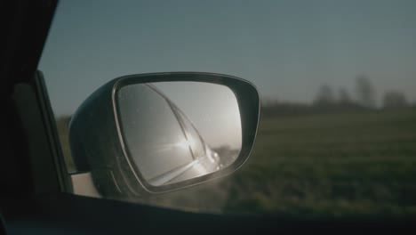 car mirror driving through landscape. fyn, denmark