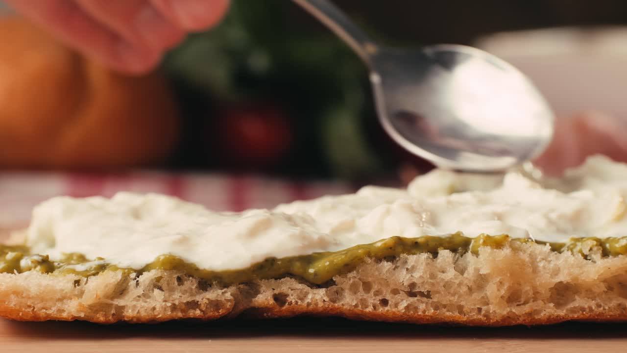 Mortadella ham sandwich, Traditional italian focaccia filled with thin pesto slices of mortadella, served by chef man in cafe restaurant. Macro of traditional italian spanish tapas antipasti.
