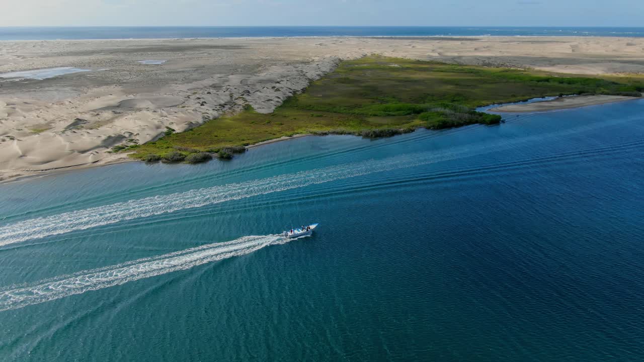Havadan görünüm. Yükselen çekim, Meksika'nın Baja California Sur bölgesindeki La Purisima kıyı şeridinden geçen turist teknesi, arka planda kıyı koyu ve deniz.