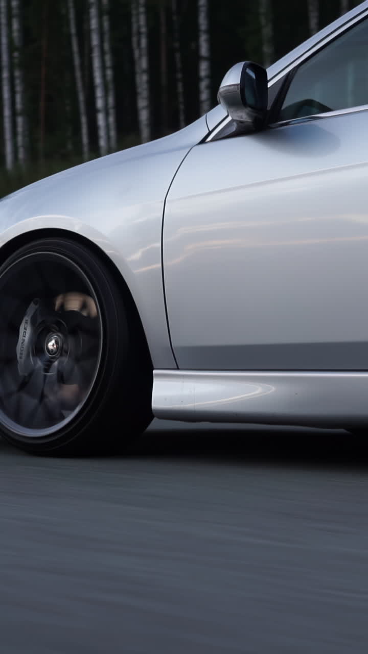 Silver Sedan on a Forest Road