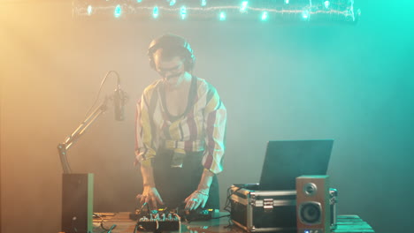 female dj playing techno music at stereo mixer