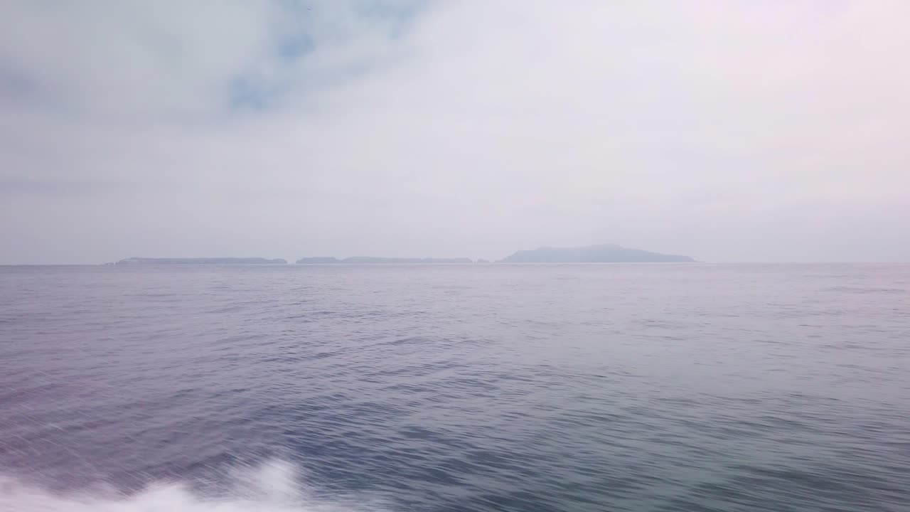 Gimbal wide shot from a moving boat in the open ocean approaching Anacapa Island in Channel Islands National Park off the coast of California