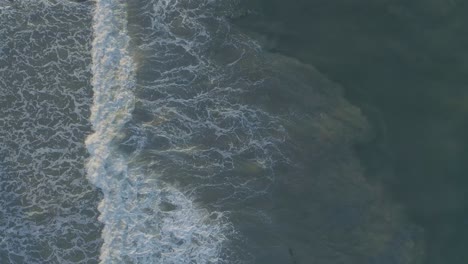 Aerial-shots-of-breaking-waves-on-a-hazy-summer-morning-in-Malibu,-California