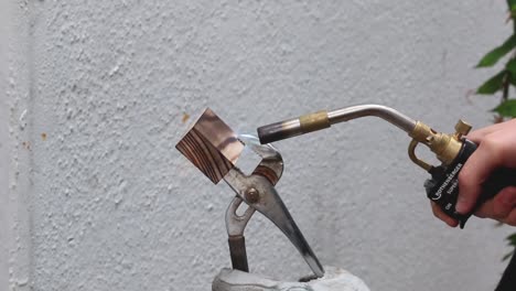 un carpintero usa un soplete para darle un acabado chamuscado a un proyecto de bricolaje de madera