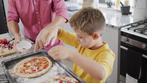 Feliz-Abuelo-Caucásico-Y-Nieto-Haciendo-Pizza-En-La-Cocina,-Cámara-Lenta