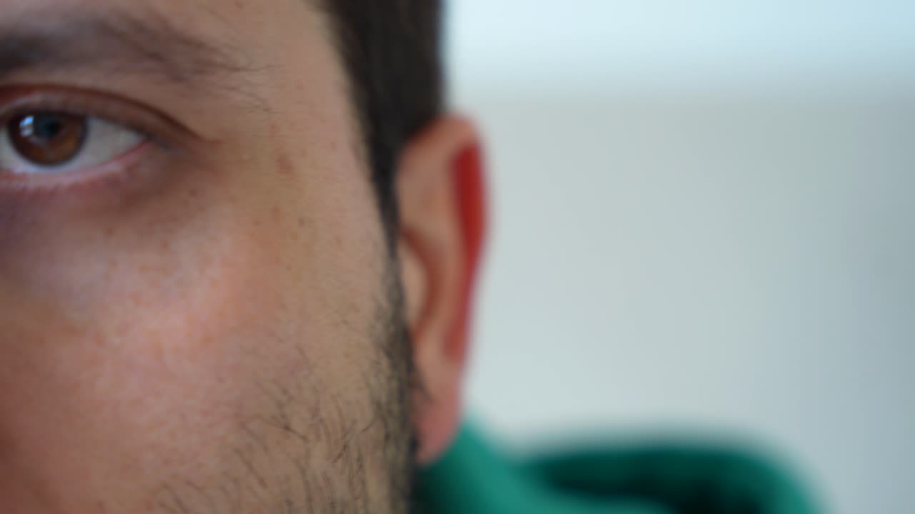 un primer plano de un hombre caucásico con ojos marrones tranquilos mirando a la cámara.