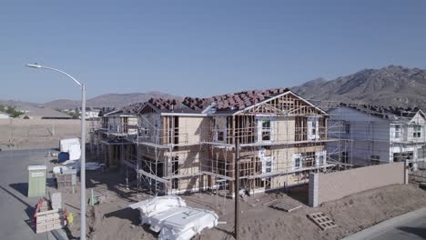 un avión no tripulado asciende lentamente hacia arriba, inclinando y bloqueando su vista en una casa parcialmente construida, proporcionando una perspectiva única y enfocada