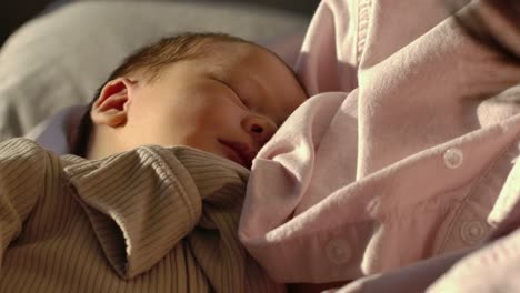 beautiful baby girl sleeps in mother's arms - slow motion