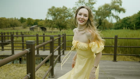 exuberant woman turning on while walking with decision on a wooden walkway in countryside