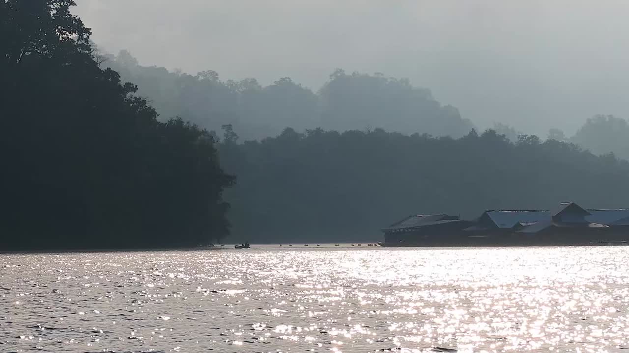 A tranquil scene of shimmering water reflecting light with distant hills in the background.