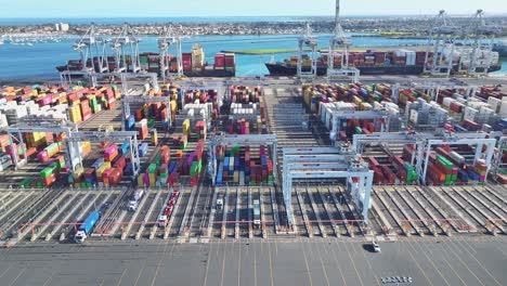 rows of stacked freight containers and cranes at melbourne port viewed from directly above
