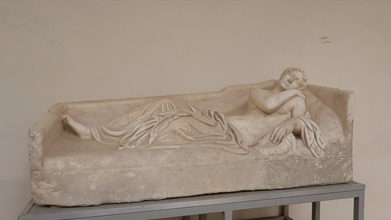 Ancient Roman marble sarcophagus featuring a beautifully carved reclining female figure in draped robes. Historic artifact displayed in a Rome museum, linked to Tivoli archaeological heritage