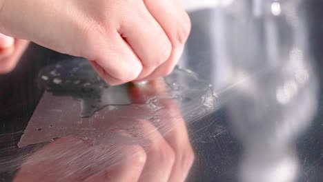 a hand methodically wipes a glass surface clean, showcasing a detailed cleaning process with close-up shots and soft lighting